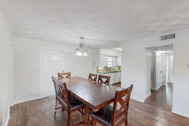 dining area with dark wood-style flooring, visible vents, and baseboards