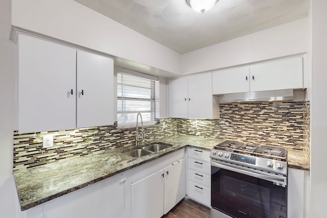 kitchen with stainless steel gas range oven, backsplash, white cabinets, range hood, and a sink