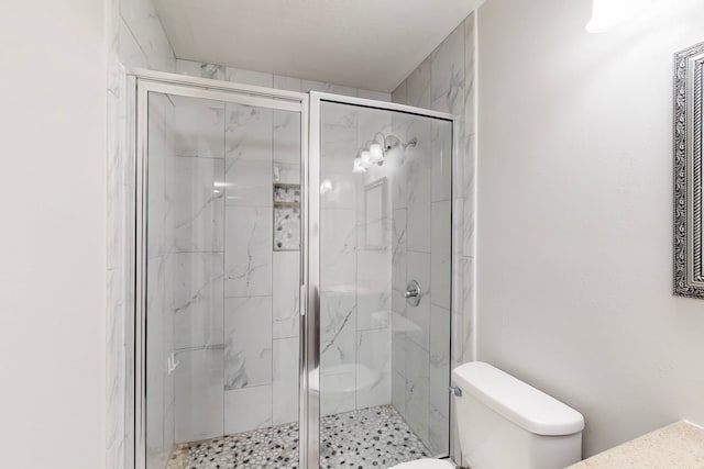 full bathroom featuring toilet and a marble finish shower