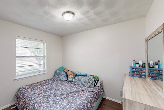 bedroom featuring baseboards and dark wood finished floors