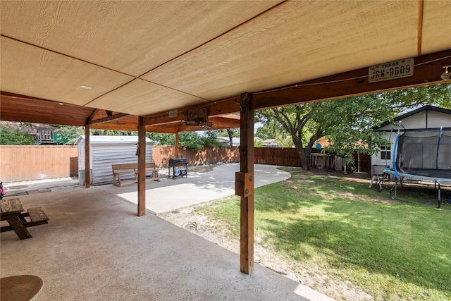 4109 Timberline Dr, Garland, TX 75042 - fenced backyard with a trampoline, a patio area, and a storage shed