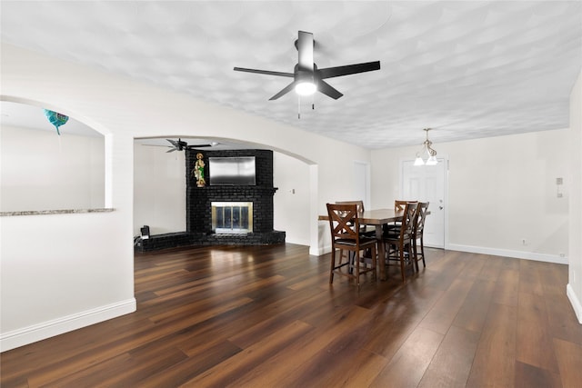 4109 Timberline Dr, Garland, TX 75042 - dining space featuring a ceiling fan, a brick fireplace, wood finished floors, and arched walkways