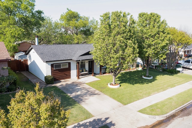 view of front facade with roof with shingles, driveway, fence, and a front lawn