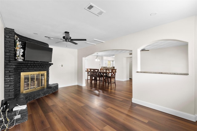 4109 Timberline Dr, Garland, TX 75042 - living room with arched walkways, a ceiling fan, a fireplace, and wood finished floors