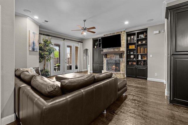 429 S Hampton Ct, Lewisville, TX 75056 - living area featuring visible vents, arched walkways, a stone fireplace, a ceiling fan, and crown molding