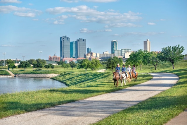 view of community with a lawn, a view of city, and a water view