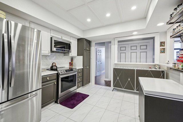 kitchen featuring recessed lighting, light countertops, appliances with stainless steel finishes, and decorative backsplash