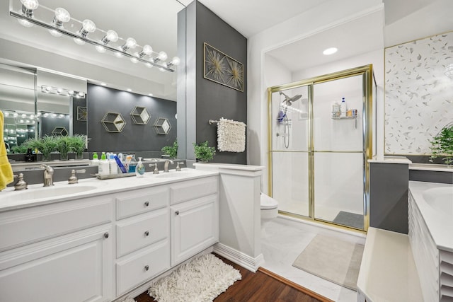 full bath featuring a sink, double vanity, toilet, and a stall shower