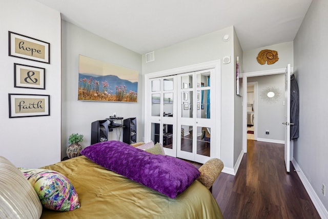 bedroom featuring a closet, french doors, baseboards, visible vents, and wood finished floors