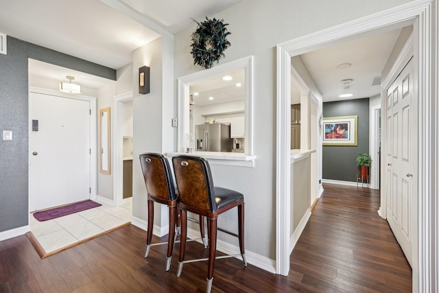 foyer entrance featuring baseboards and dark wood-style floors