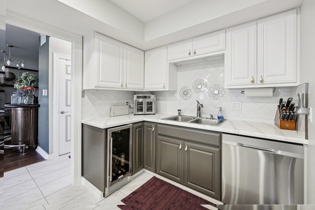 kitchen featuring beverage cooler, a sink, white cabinetry, stainless steel dishwasher, and gray cabinetry