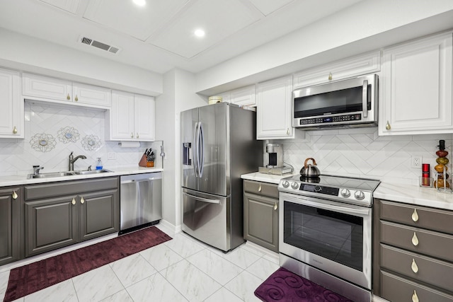 kitchen featuring a sink, stainless steel appliances, white cabinetry, visible vents, and gray cabinetry