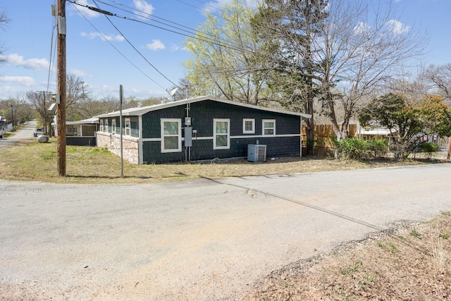 view of front of house featuring cooling unit and fence