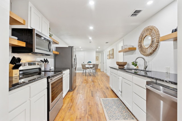 kitchen with visible vents, open shelves, a sink, white cabinetry, and stainless steel appliances