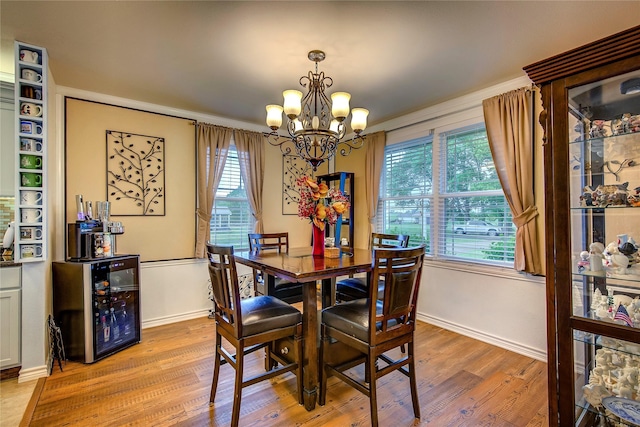 dining space with plenty of natural light, light wood-type flooring, a chandelier, and baseboards