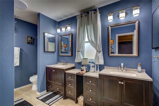 full bathroom featuring toilet, tile patterned floors, two vanities, and a sink