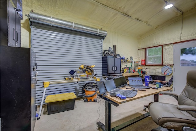 office area featuring unfinished concrete flooring