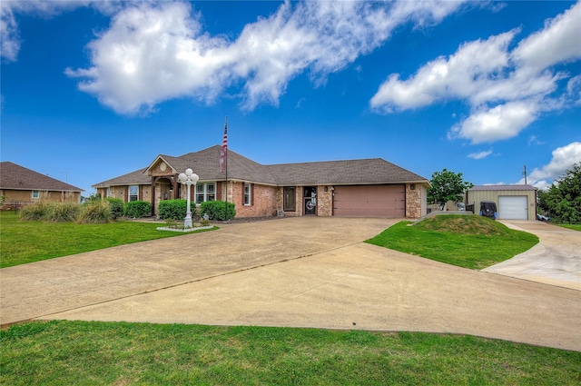 ranch-style home featuring a garage, a front yard, brick siding, and driveway