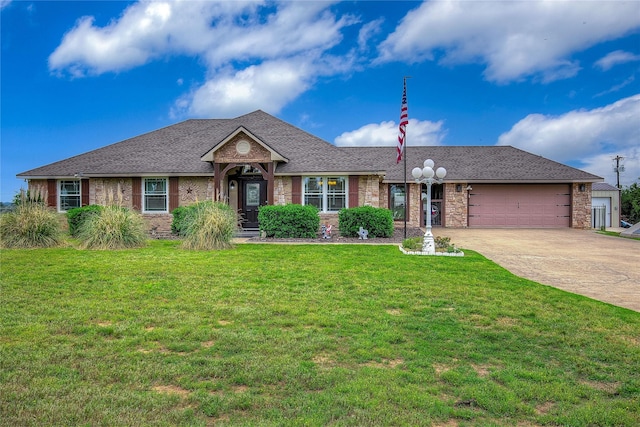 ranch-style home with a front lawn, roof with shingles, a garage, and concrete driveway