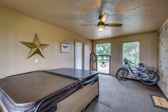 playroom with brick wall, ceiling fan, and tile patterned floors