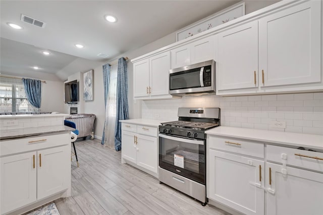 kitchen featuring tasteful backsplash, light wood-type flooring, white cabinetry, visible vents, and stainless steel appliances