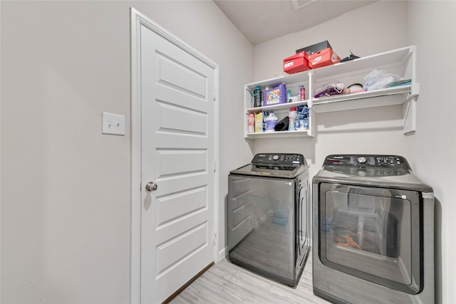 laundry room featuring washing machine and clothes dryer, light wood-type flooring, and laundry area