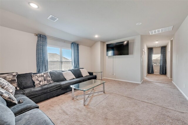 carpeted living room with baseboards, visible vents, and a wealth of natural light