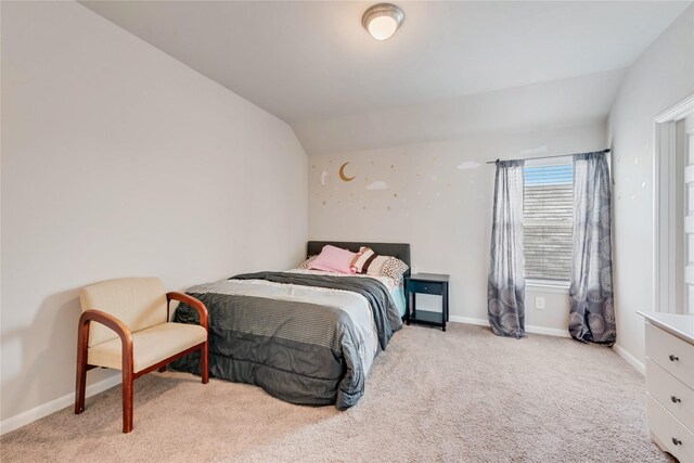 carpeted bedroom with baseboards and lofted ceiling