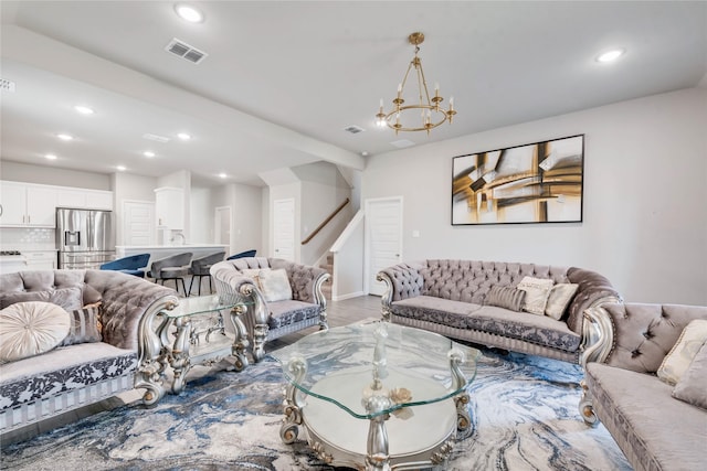 living area with visible vents, a notable chandelier, light wood-style floors, recessed lighting, and stairs