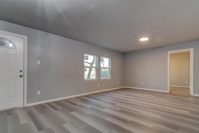 702 N Virginia, Terrell, TX 75160 - entrance foyer with baseboards, light wood-type flooring, and a textured ceiling