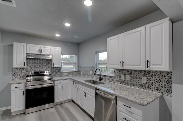 702 N Virginia, Terrell, TX 75160 - kitchen featuring tasteful backsplash, under cabinet range hood, light stone countertops, stainless steel appliances, and a sink