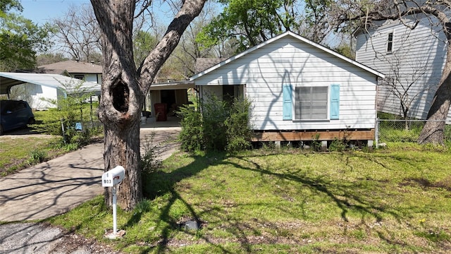 single story home with fence, driveway, a front yard, and a carport