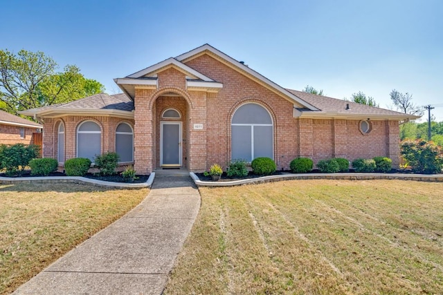 view of front facade featuring brick siding and a front lawn