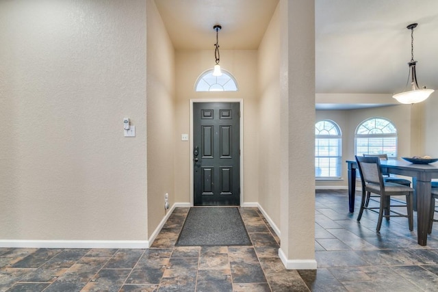 dining space featuring stone finish flooring, baseboards, and vaulted ceiling