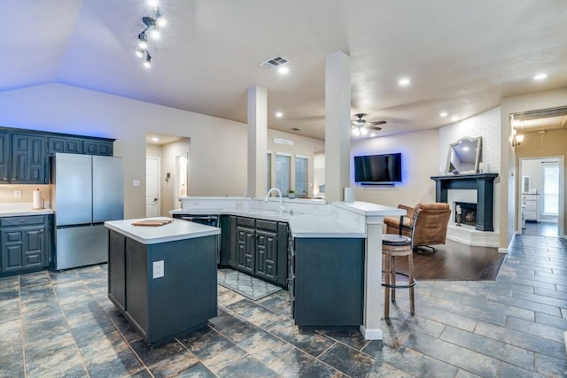 kitchen with oven, a sink, visible vents, and a kitchen island