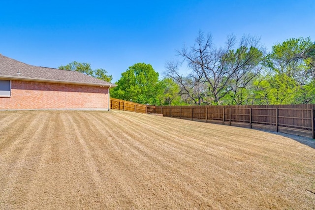 exterior space featuring central air condition unit, a lawn, fence, brick siding, and a garage