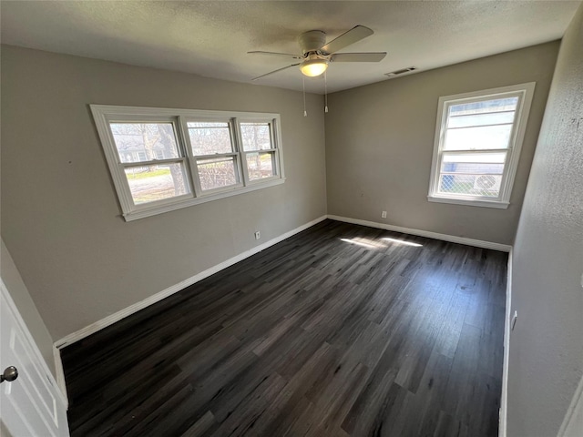 2912 W Elm St, Denison, TX 75020 - unfurnished room featuring visible vents, baseboards, a ceiling fan, and dark wood-style floors