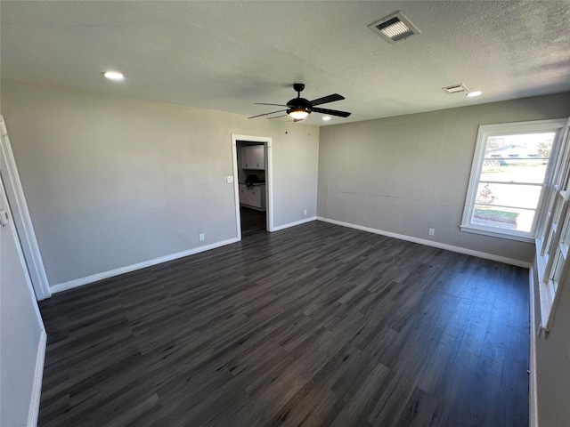 2912 W Elm St, Denison, TX 75020 - spare room with visible vents, baseboards, dark wood-style flooring, ceiling fan, and a textured ceiling