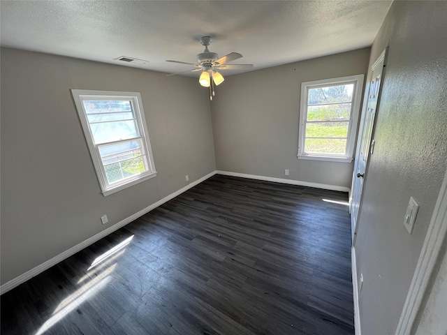 2912 W Elm St, Denison, TX 75020 - spare room with dark wood-style flooring, visible vents, baseboards, and a ceiling fan