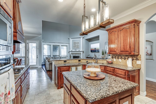 500 Lismore Dr, Mansfield, TX 76063 - kitchen featuring a peninsula, open floor plan, brown cabinetry, decorative backsplash, and stainless steel appliances