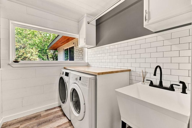 505 Heyser Dr, Dallas, TX 75224 - laundry room with washer and dryer, cabinet space, a sink, and light wood-type flooring