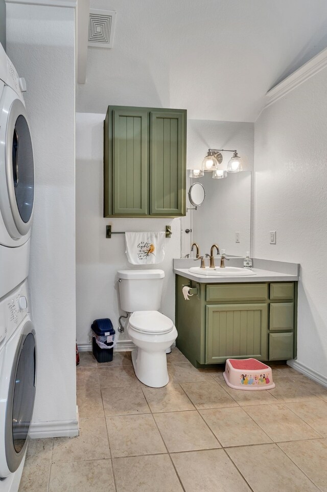 105 Park Trail Pl, Joshua, TX 76058 - bathroom featuring stacked washer and clothes dryer, toilet, vanity, tile patterned floors, and ornamental molding