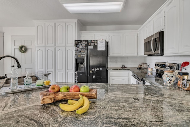 105 Park Trail Pl, Joshua, TX 76058 - kitchen with stainless steel appliances, white cabinetry, dark stone counters, tasteful backsplash, and a sink