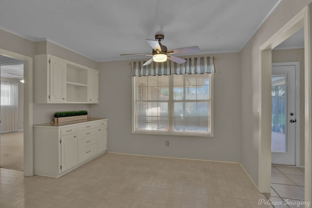 7321 Montclair Dr, Shreveport, LA 71105 - kitchen with open shelves, white cabinetry, ceiling fan, ornamental molding, and baseboards