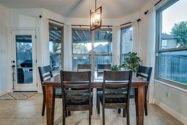 dining area featuring baseboards, a notable chandelier, and light tile patterned flooring