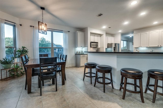 kitchen with decorative backsplash, a healthy amount of sunlight, stainless steel appliances, and visible vents
