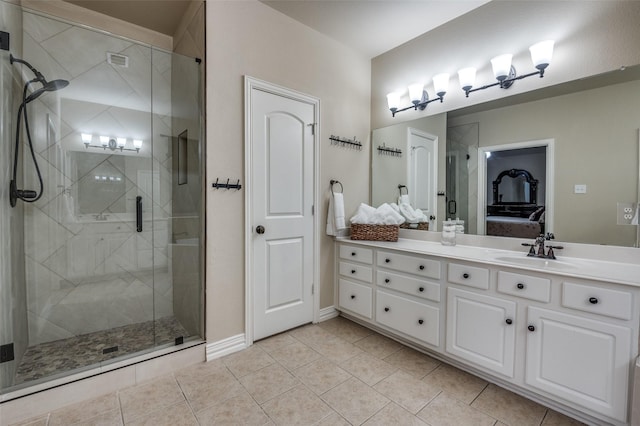 ensuite bathroom featuring a stall shower, vanity, ensuite bath, baseboards, and tile patterned flooring