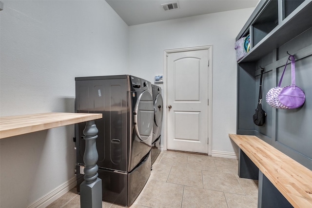 laundry room with baseboards, visible vents, independent washer and dryer, laundry area, and light tile patterned floors