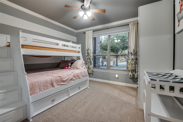 carpeted bedroom featuring ceiling fan, baseboards, and ornamental molding