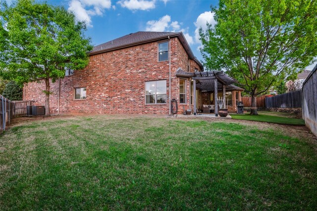back of house with a pergola, a fenced backyard, central air condition unit, a lawn, and brick siding